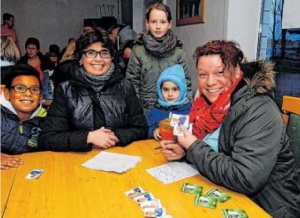 Silke Doukouré (r.) und ihr Sohn Tidiane (l.) haben sich mit Tanja Jäger und ihren Kindern Nikita und Anja (Mitte) an einen Tisch gesetzt, um Sammelalbum voll zu bekommen. FOTO: HEIKE VON SCHULZ